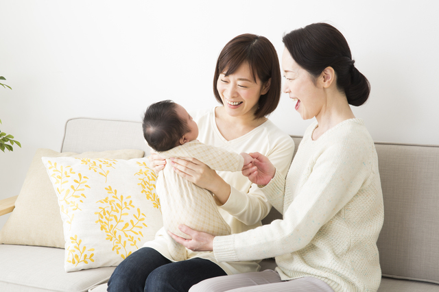 赤ちゃんと触れ合う女性たち