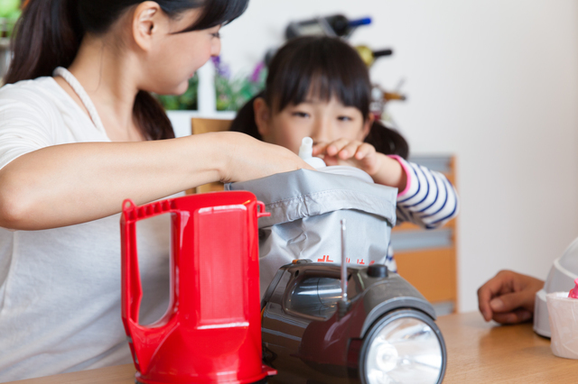 避難用の荷物を詰める親子