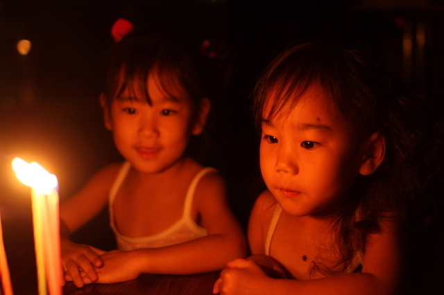 ろうそくの火を見つめる子どもたち