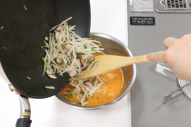 炒めた野菜を玉子にくわえる