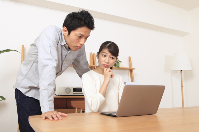 PCを見ながら悩む女性と男性