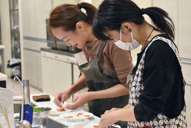 料理をお皿に盛り付ける参加者