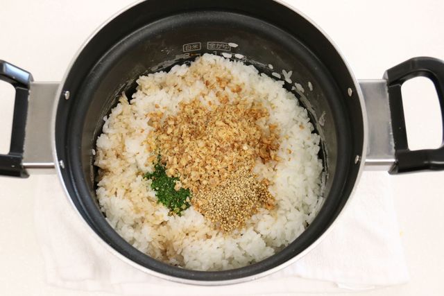 炊きあがったご飯に具材を加えて混ぜ合わせる