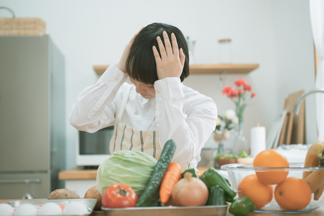 野菜を前に頭を抱える人