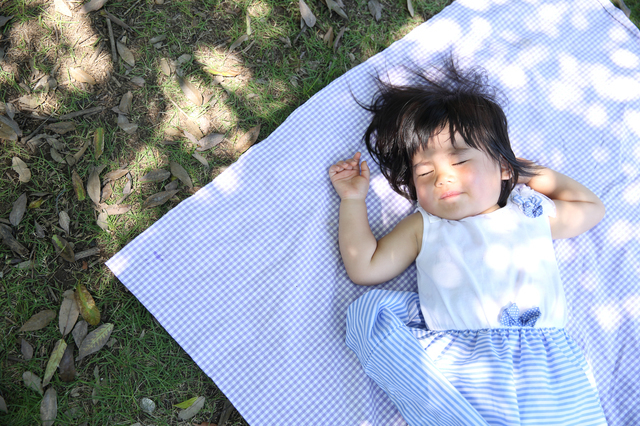 屋外で昼寝する子ども