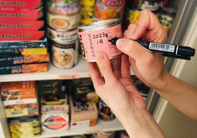 防災食の消費期限をペンで記入しているところ
