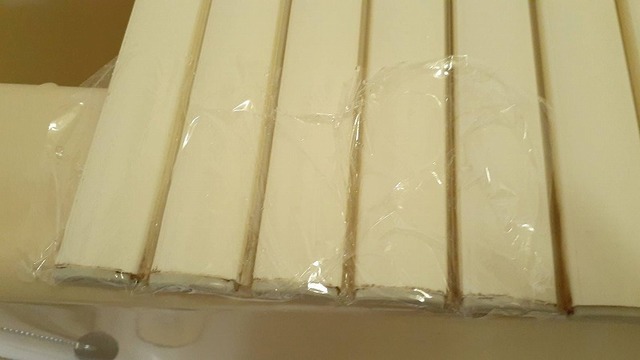 カビと利用洗浄剤をかけたお風呂のフタにラップをしているところ