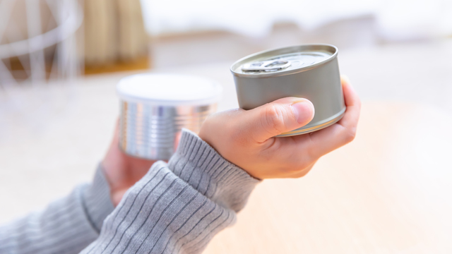 缶詰を確認する女性の手元