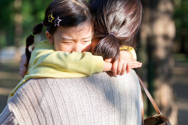 親に抱きかかえられている子どもの様子