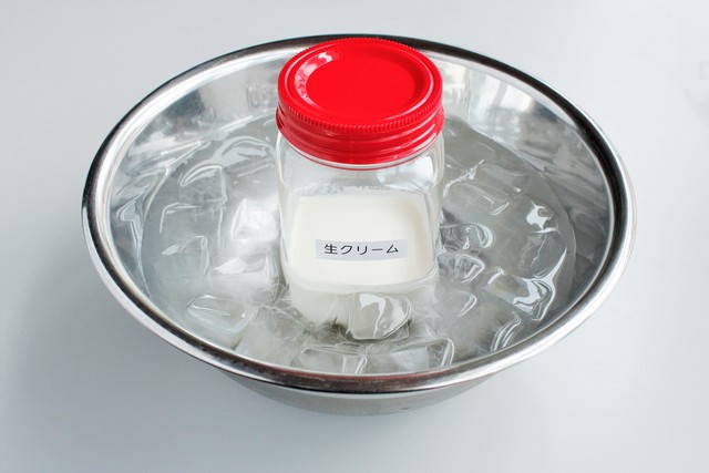 氷水の中で生クリームの入った容器を冷やしている様子