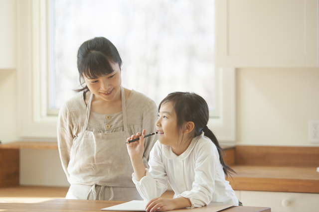考えている女の子と見守る母親
