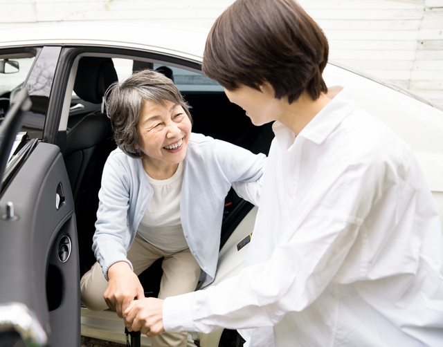 母親の手を取り支える女性