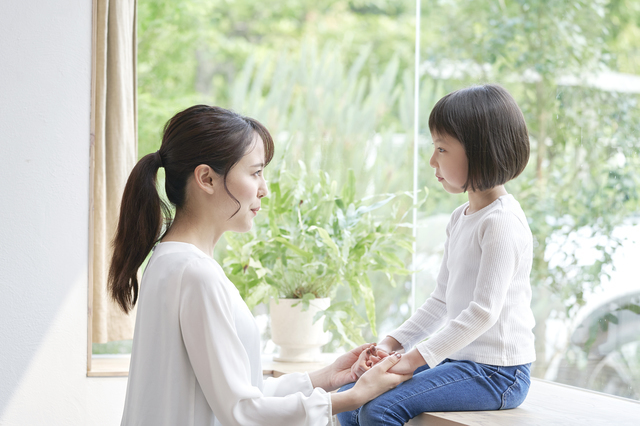 子どもに向かい合う母親のイメージ