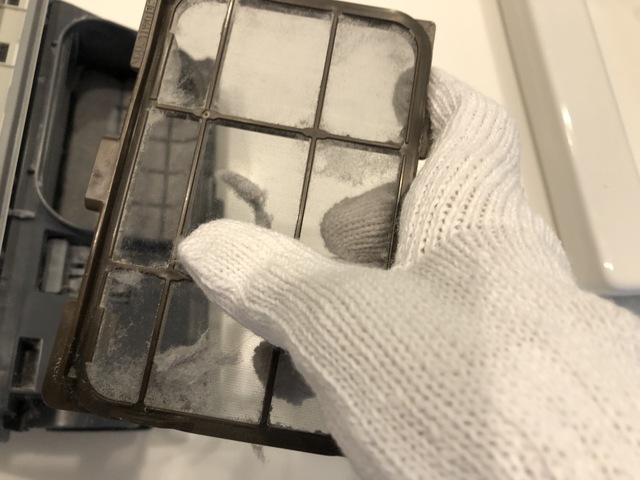 軍手でフィルター部分の汚れを落とす様子