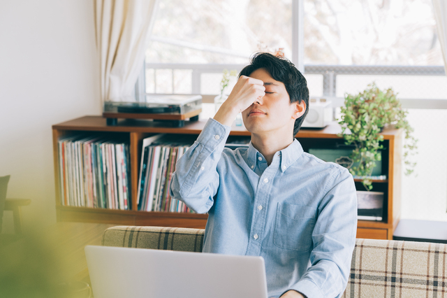 PC作業の合間に目頭を押さえる男性