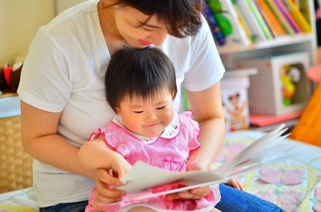 赤ちゃんに絵本を読んであげているところ