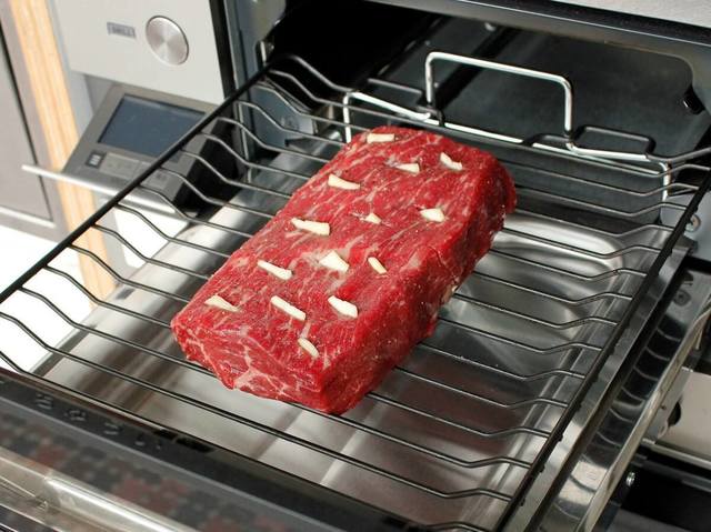 肉に切り込みを入れ、ニンニクの薄切りを刺した状態