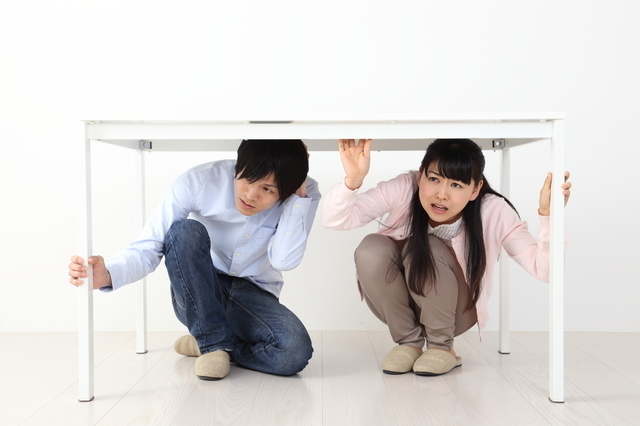 机の下に隠れる人たち