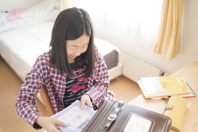 ランドセルに荷物を入れる子ども
