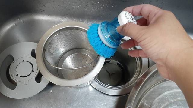 排水口を掃除専用ブラシで掃除する