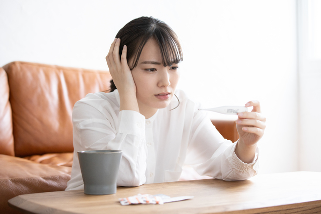 体温計を見て頭を抱える女性