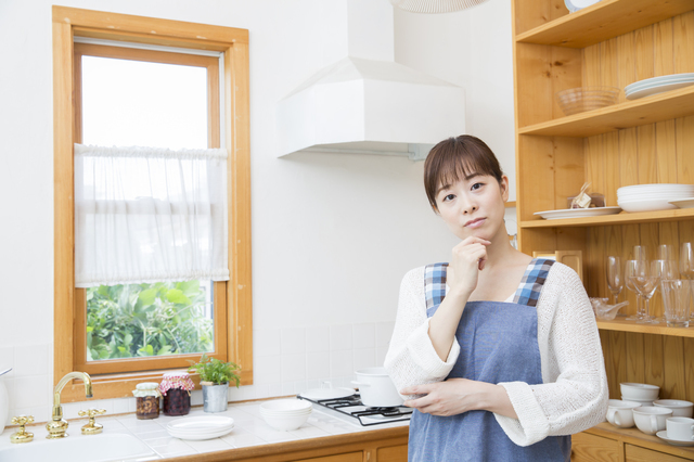 キッチンで悩む女性