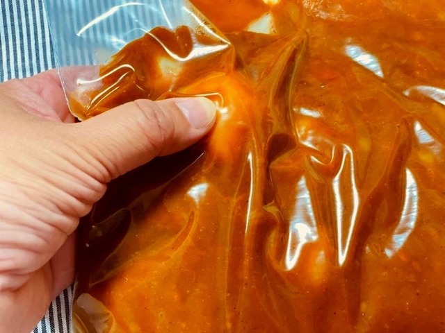 保存袋に入ったカレーの具材をつぶす様子