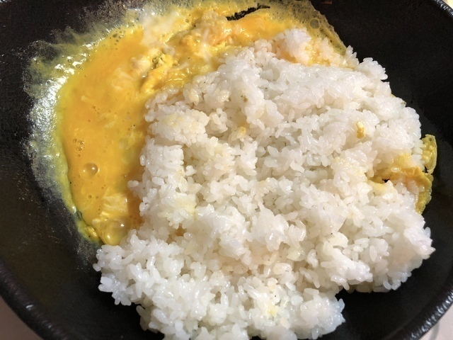 炒めた卵にごはんをくわえる