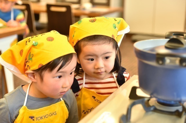 ガスコンロの火を眺める子どもたち