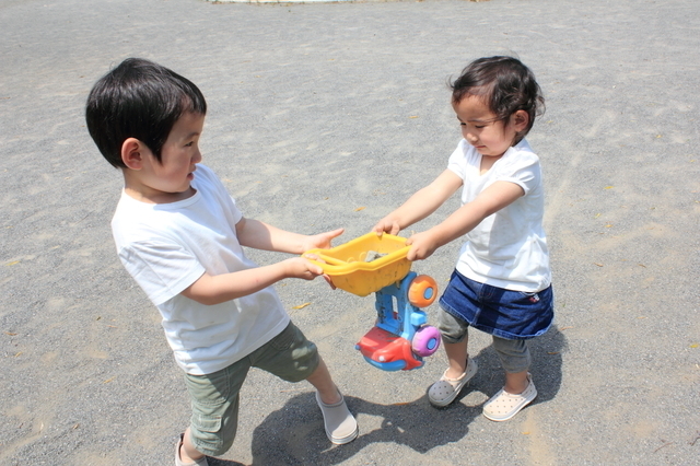 おもちゃの取り合いをする男の子たち