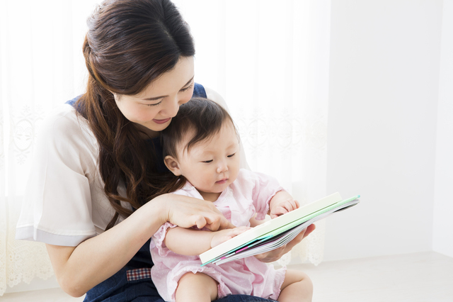赤ちゃんに絵本を読む母親