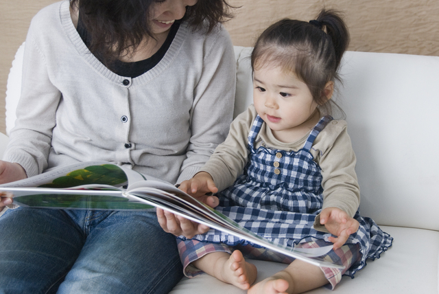 母親と一緒に絵本を読む子ども