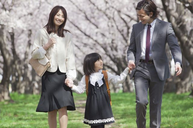 桜並木を歩く親子