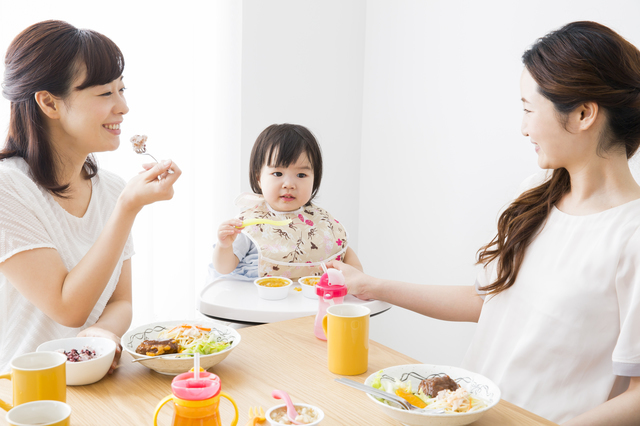 食事をする赤ちゃんと女性たち
